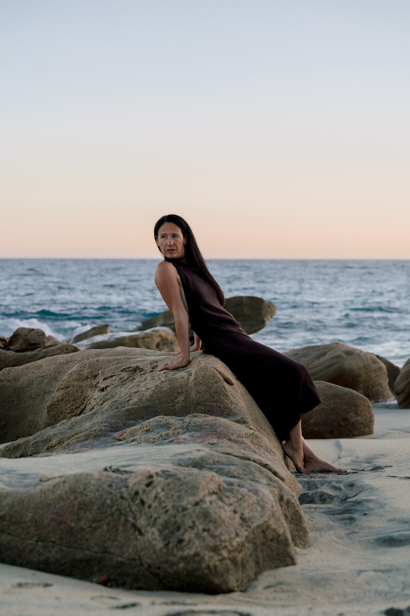 Lisa Axford seated on coastal rocks