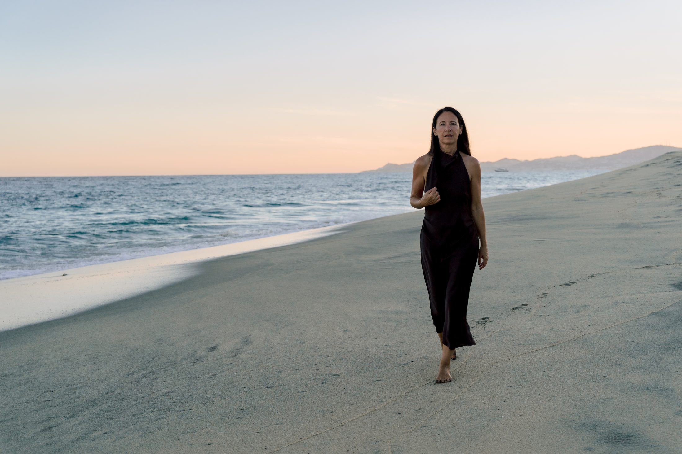 Lisa Axford walking along the shoreline at dusk
